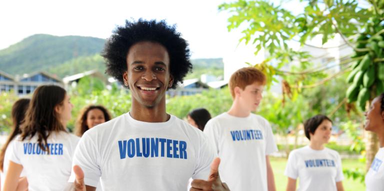 Man wearing Volunteer T-shirt and giving thumbs up sign