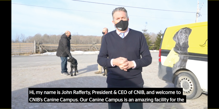 A thumbnail for a video of a virtual tour through CNIB's Canine Campus. The image shows John Rafferty greeting the viewer, and introducing the Canine Campus.