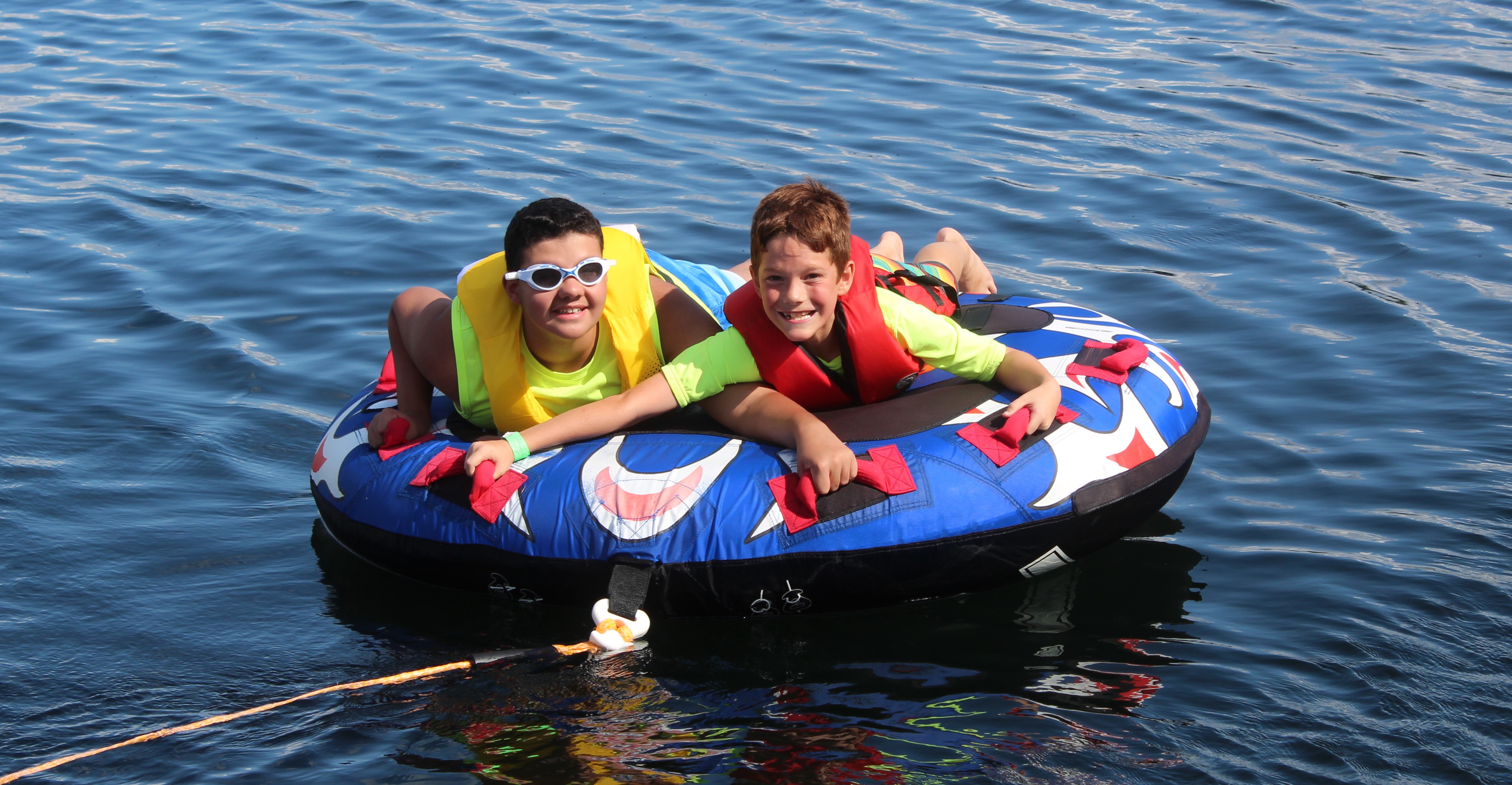 Two boys with sight loss on a tube on a lake