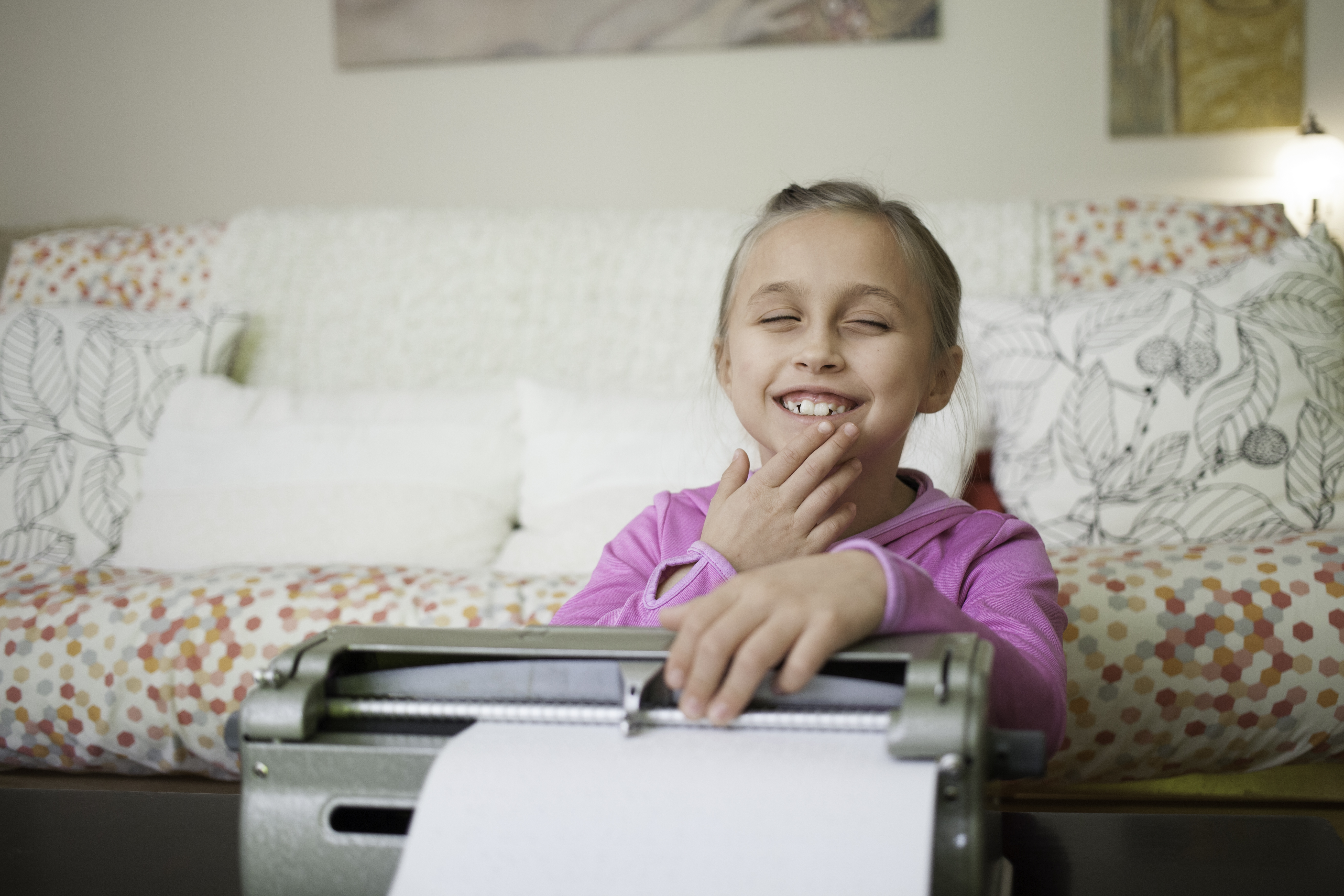 A child with sight loss using a Braille typewriter
