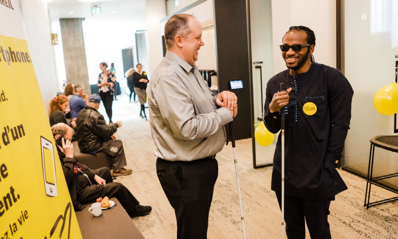 Two colleagues who are blind chatting in a conference room on a break