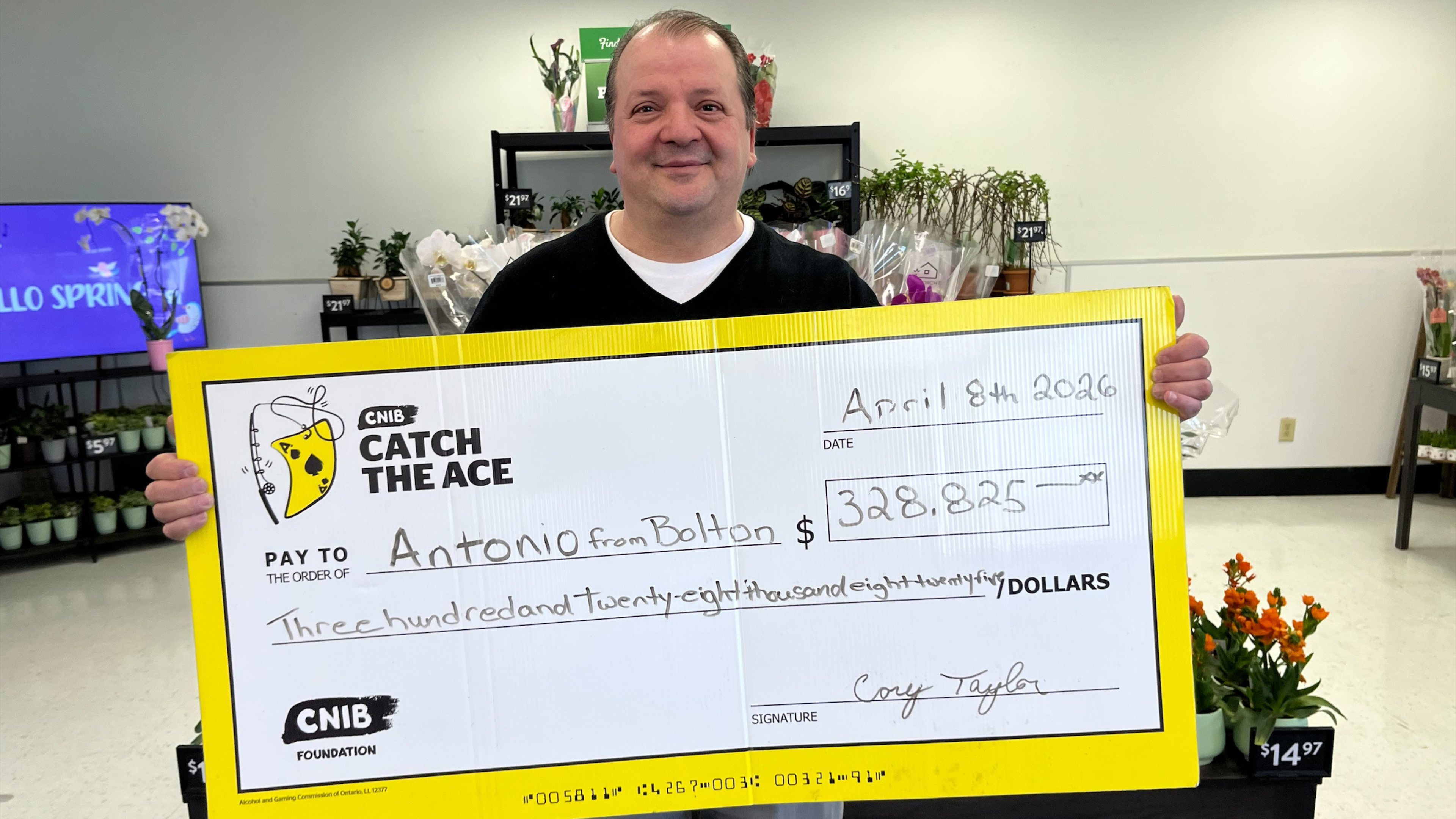  Antonio, a Catch the Ace jackpot winner, smiles and holds a giant signed cheque.