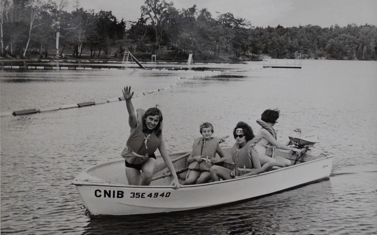 Black and white photo from the 1960s of four girls in a boat at Lake Joe
