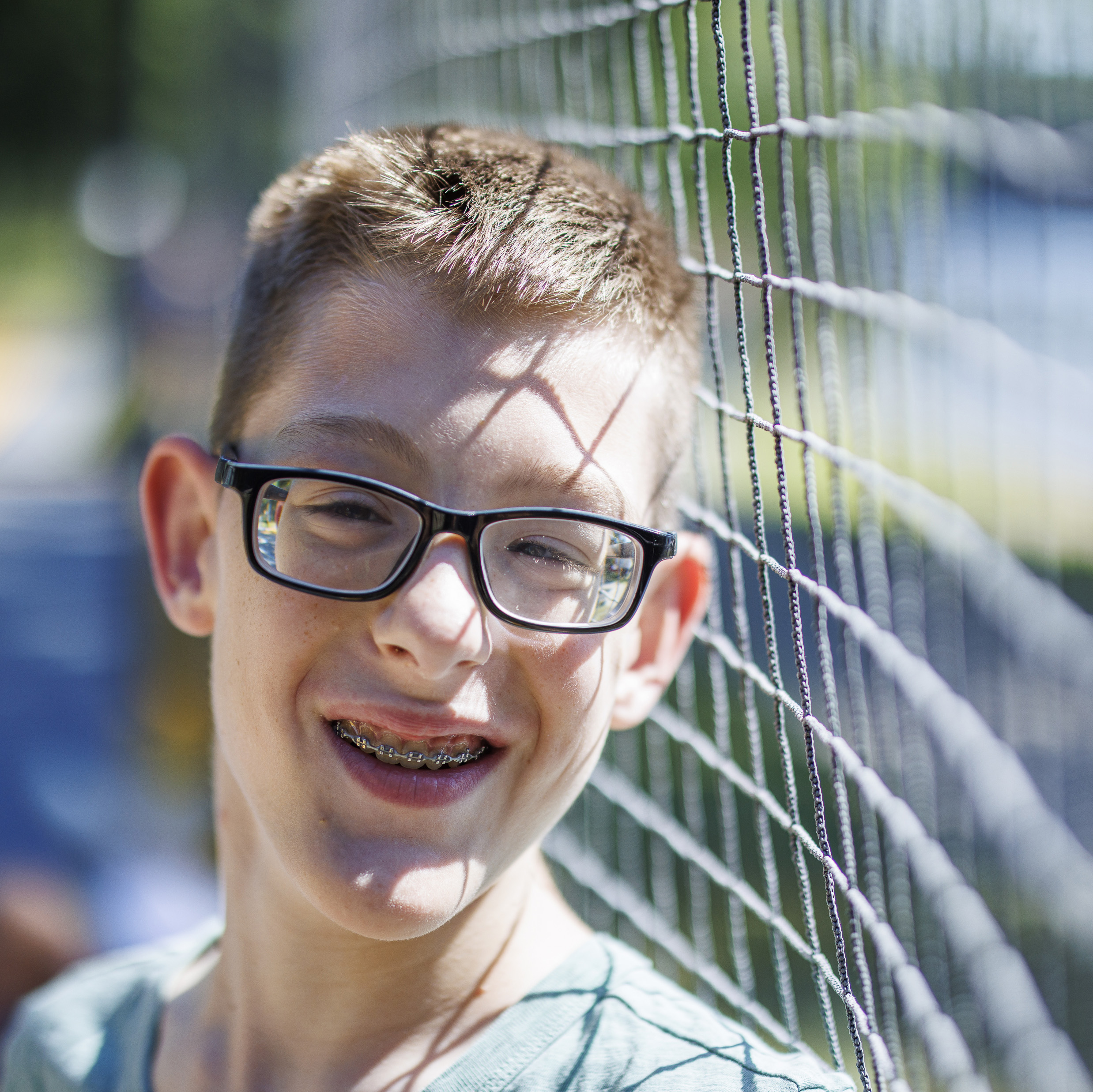 Boy with light skin and glasses smiling
