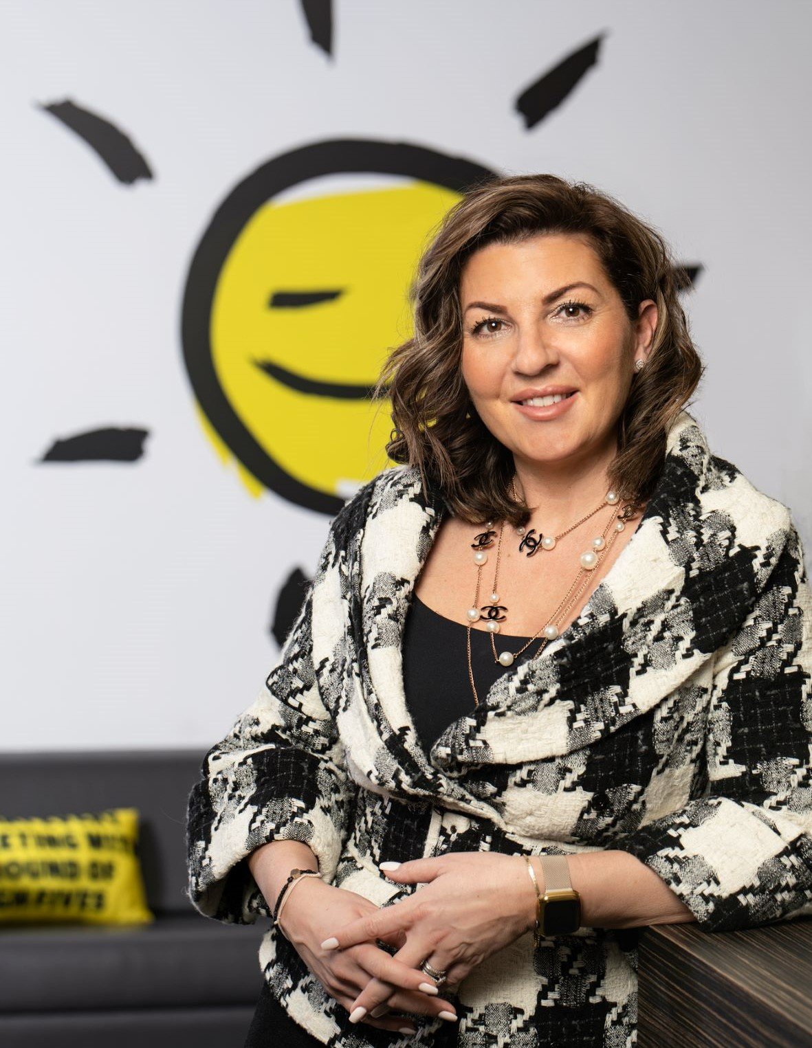 Angela Bonfanti smiling and leaning against a desk