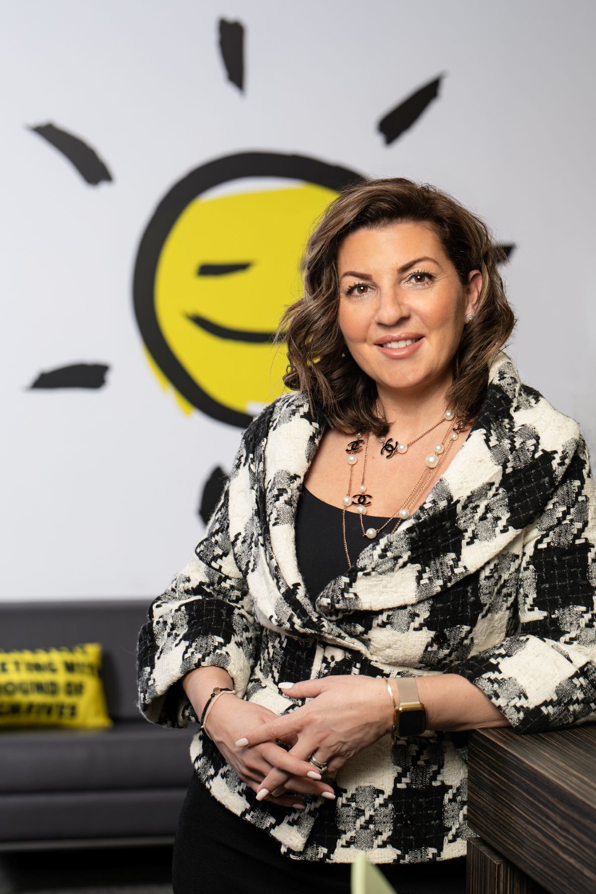 Angela Bonfanti smiling and leaning against a desk