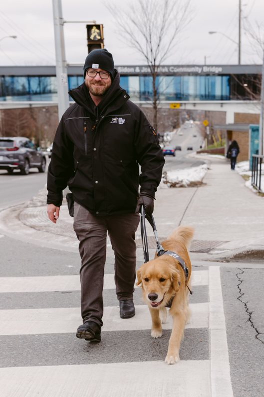 Rob Cramer crossing a street with a guide dog in training