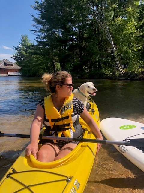 Alessia Tuilli with guide dog in a kayak on the water at CNIB Lake Joe.