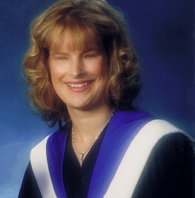 Holly Bartlett wearing a graduation gown, smiling 
