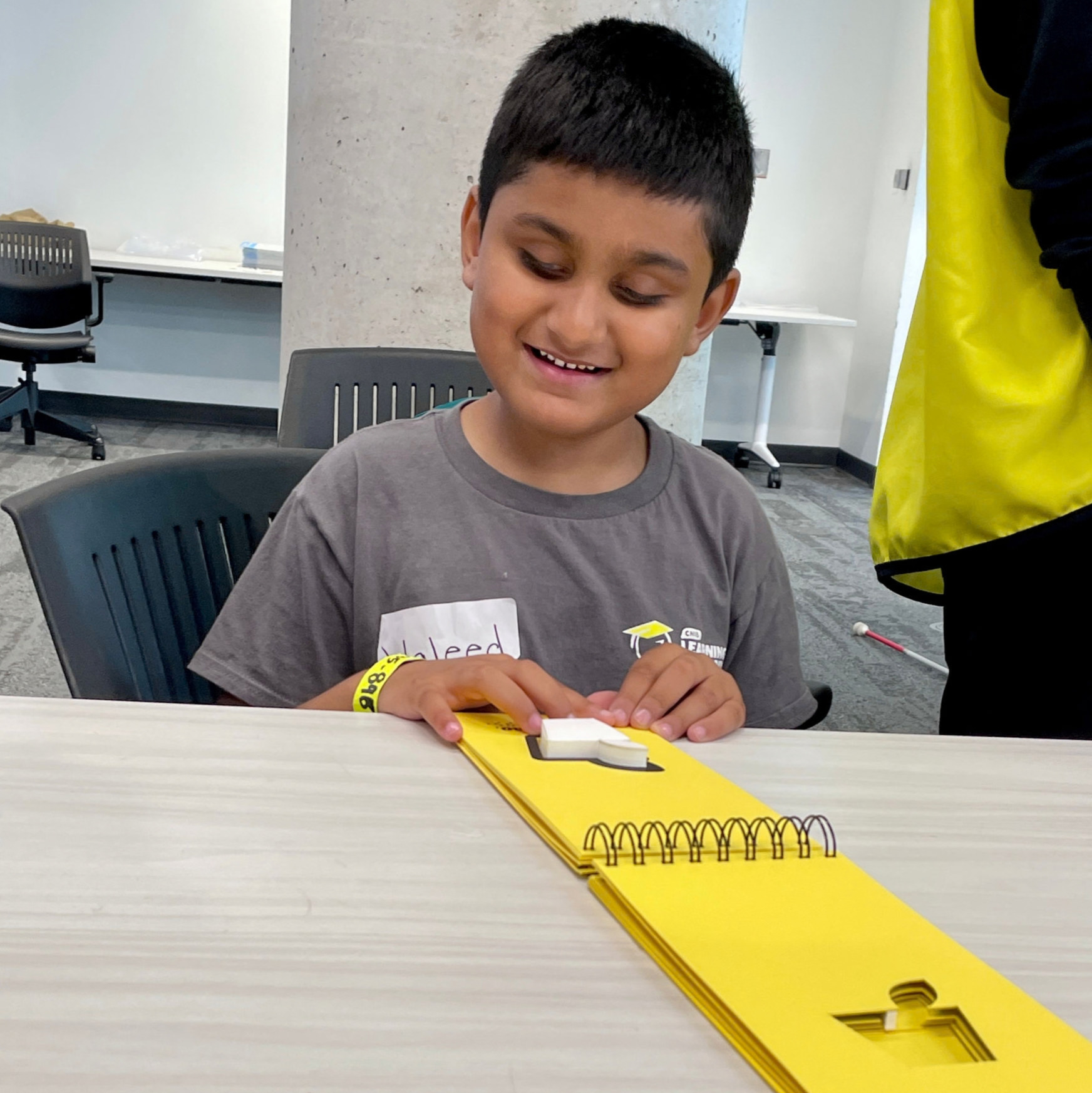 A young boy reading braille at CNIB Learning Academy.