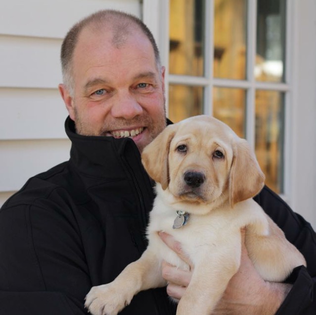 Carl holding eight-week old future guide dog Sherman