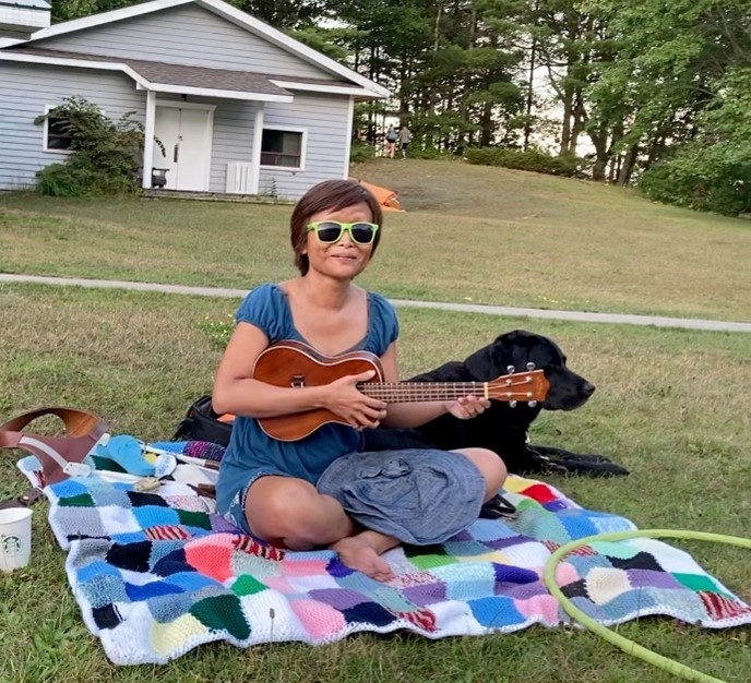​​Vivian playing her ukelele on the lawn at CNIB Lake Joe.