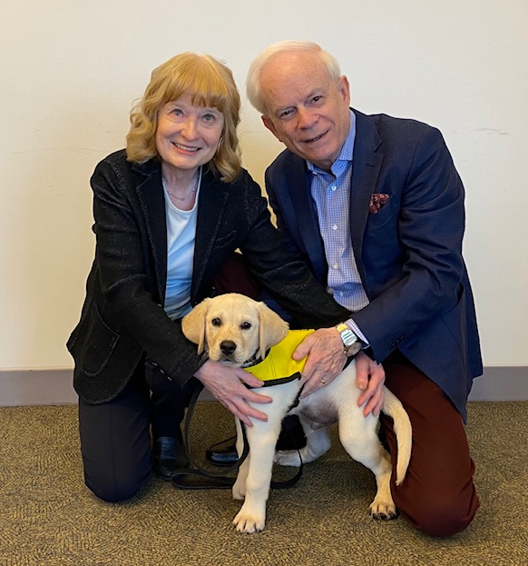 John et Mary Crocker agenouillés à côté d’un futur chien-guide.