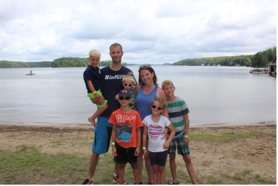La famille Knip posant pour l'appareil photo sur la rive du Lake Joseph. 