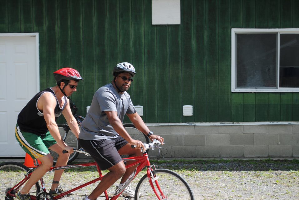 Derek Thompson et Shawn Dale enfourchent un vélo tandem rouge au Centre Lake Joe d’INCA. 