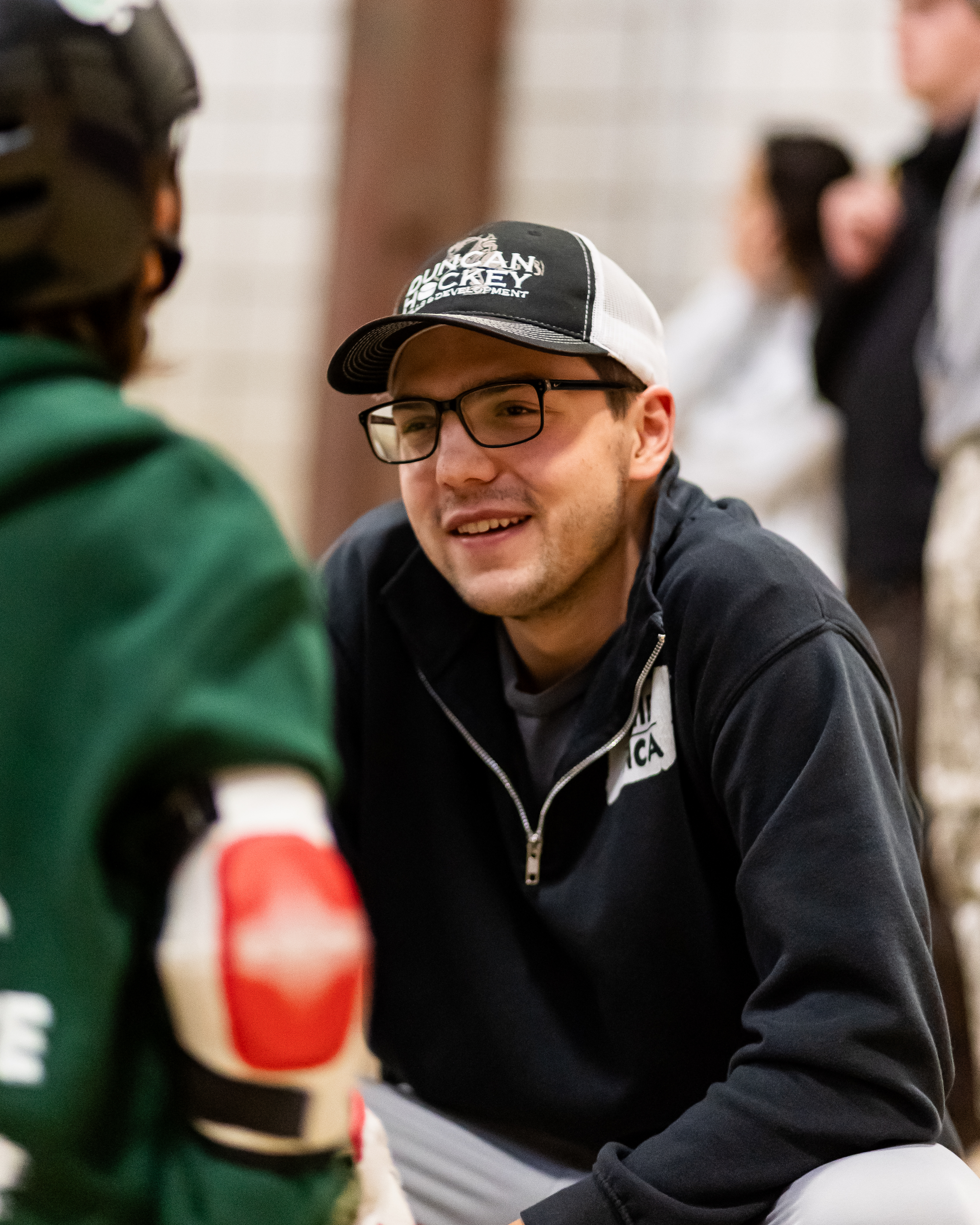 Curtis smiling while speaking to a younger fellow skateboarder.
