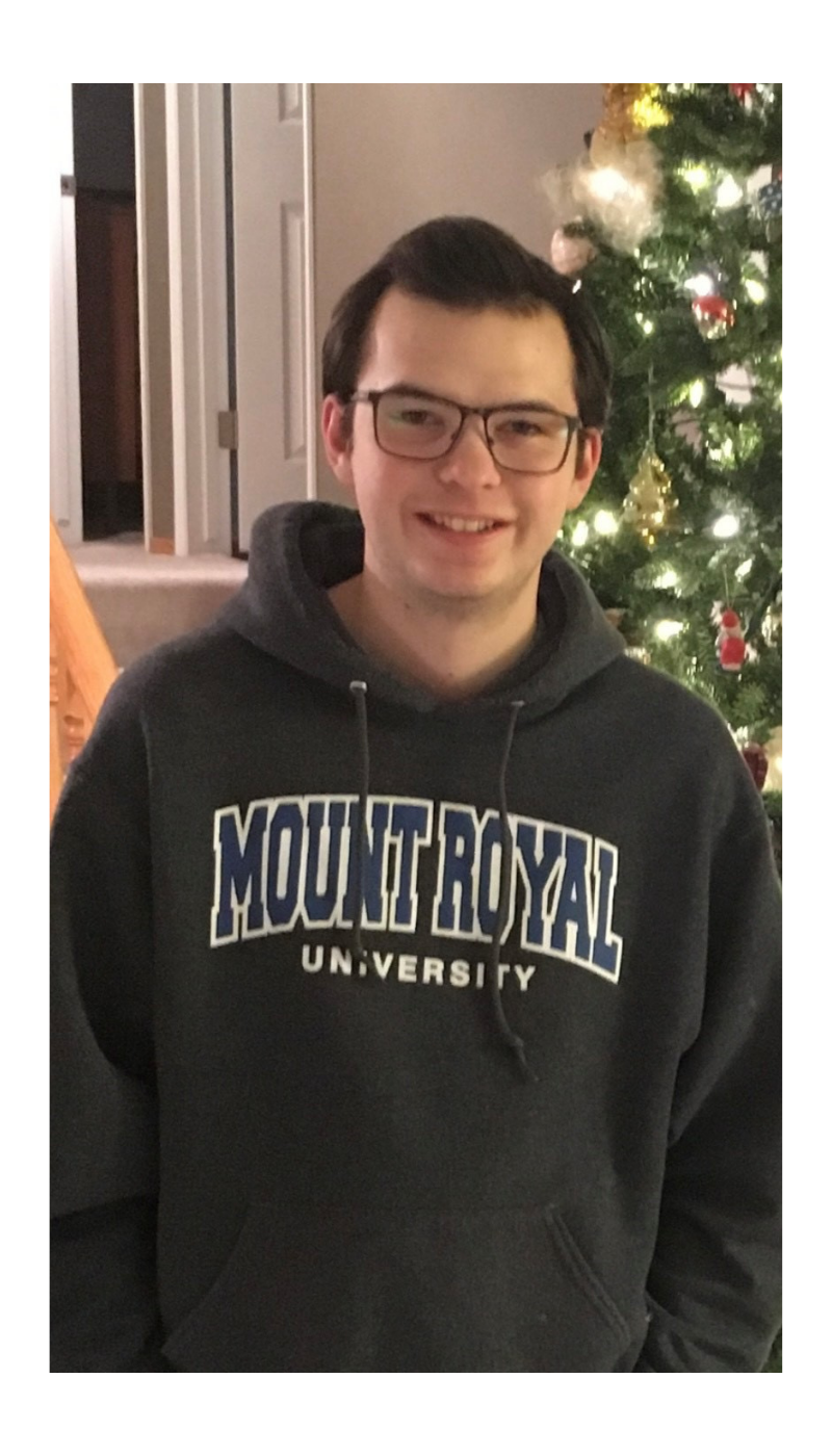  A photograph of Mark wearing a Mount Royal University hoodie.
