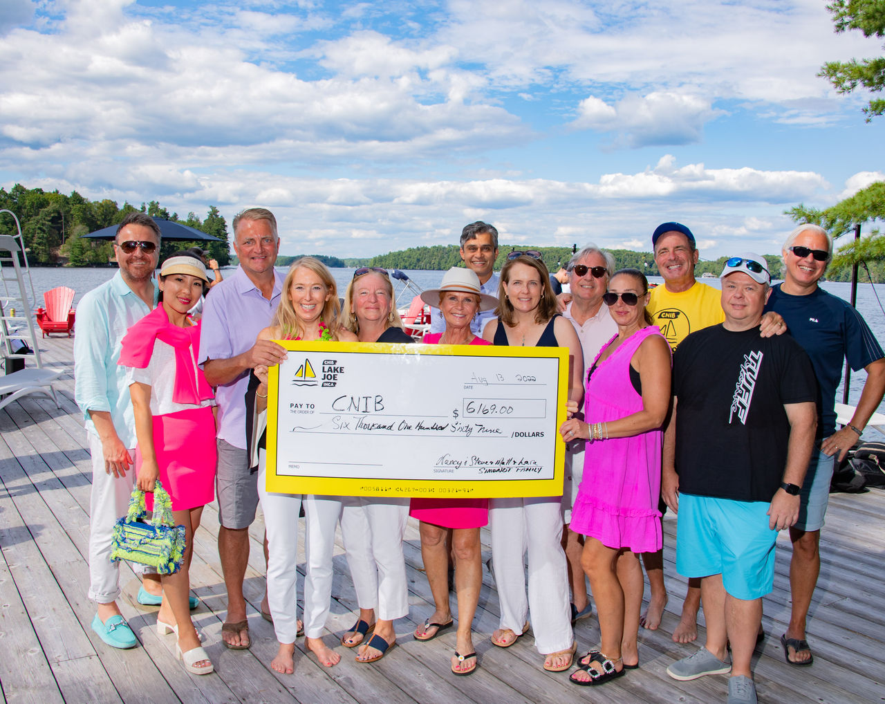 A group of people holding up a large cheque made out to CNIB