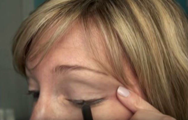 Woman applying eyeliner