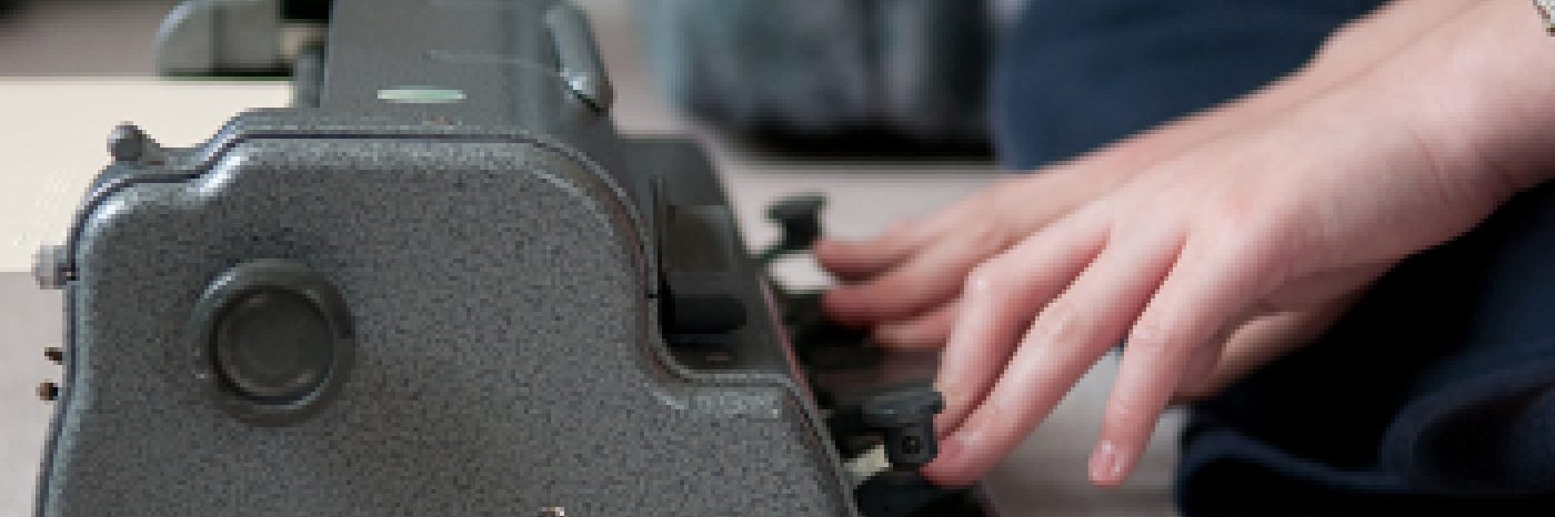 Des mains tapant sur un brailleur Perkins.