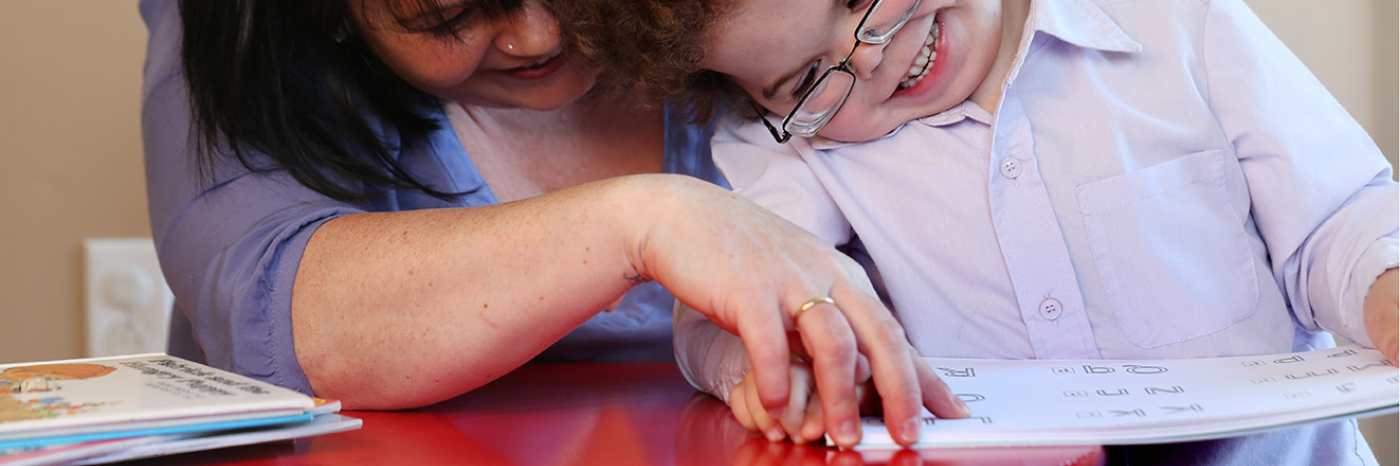 Mother and son reading a braille book