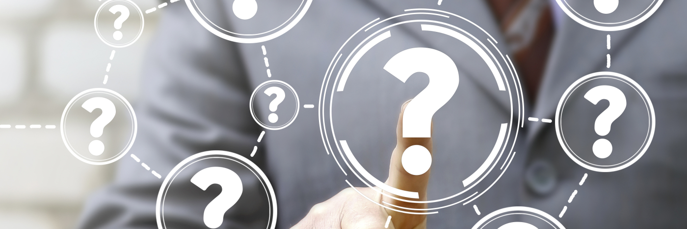 A finger points at a bunch of questions marks