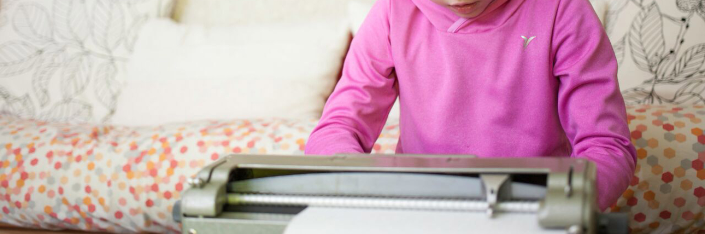 Little girl using a  brailler
