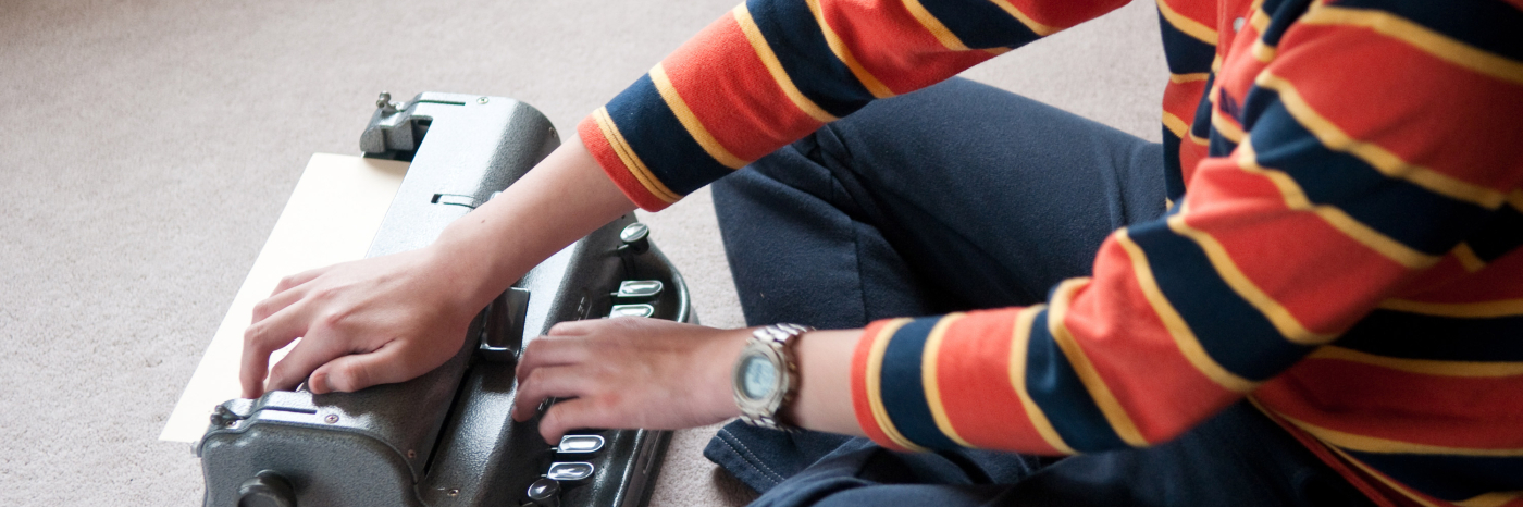 Boy using a brailler