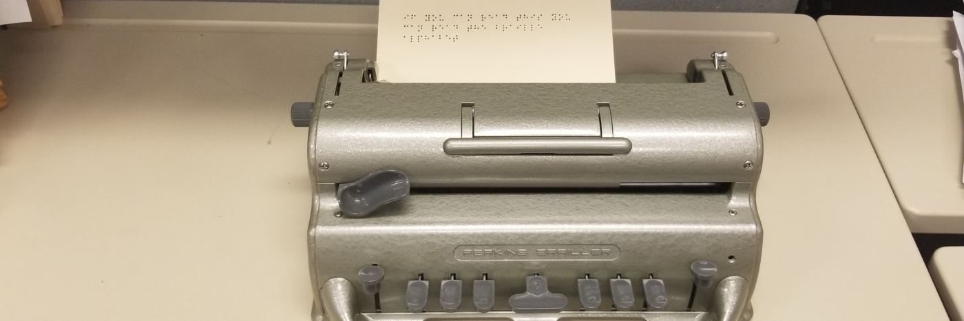 Perkins Brailler with braille message on paper saying "if you can read this you can read the braille alphabet"