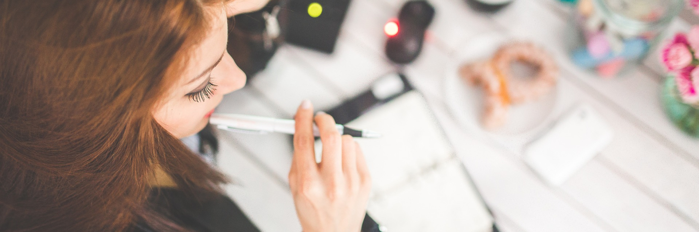A young woman studies with a notebook on her desk.