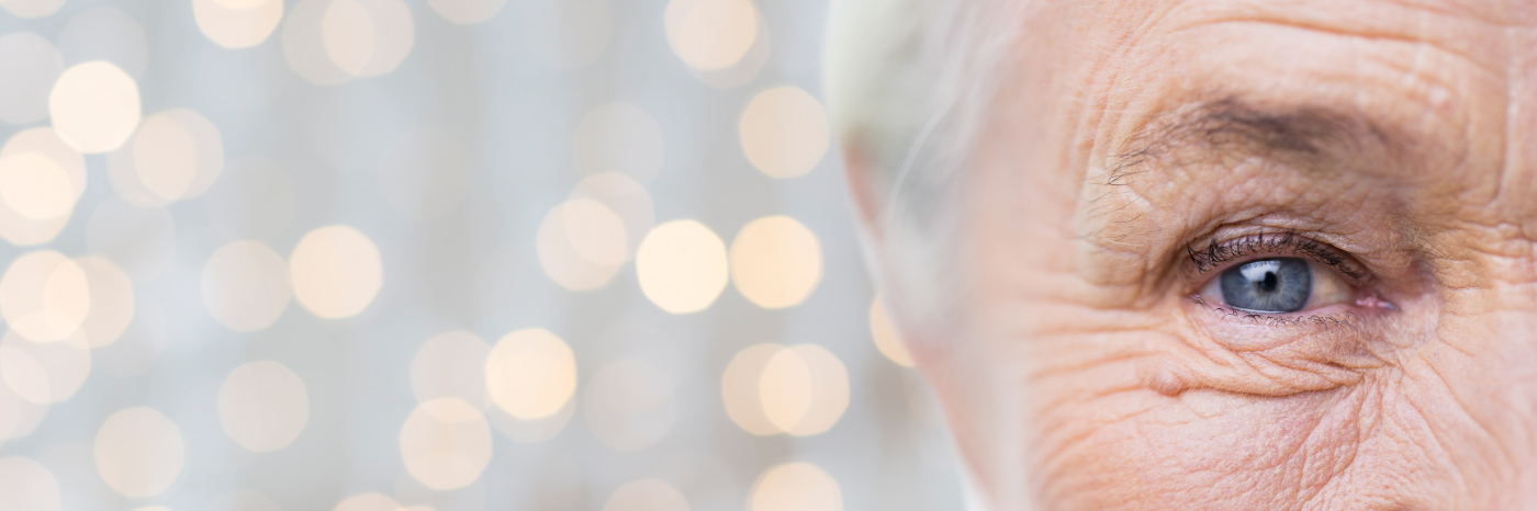 Image of a senior's eye with faded colour lights in the background