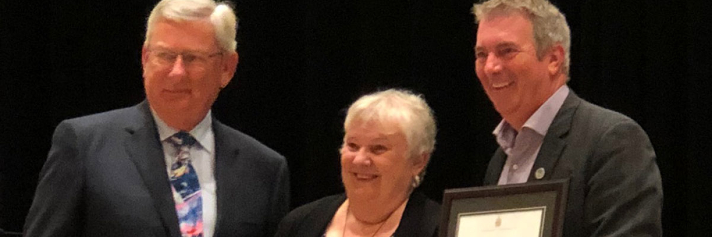 John Magill and  John Rafferty standing with Louise Gillis, recipient of the Arthur Napier Magill Distinguished Service Award