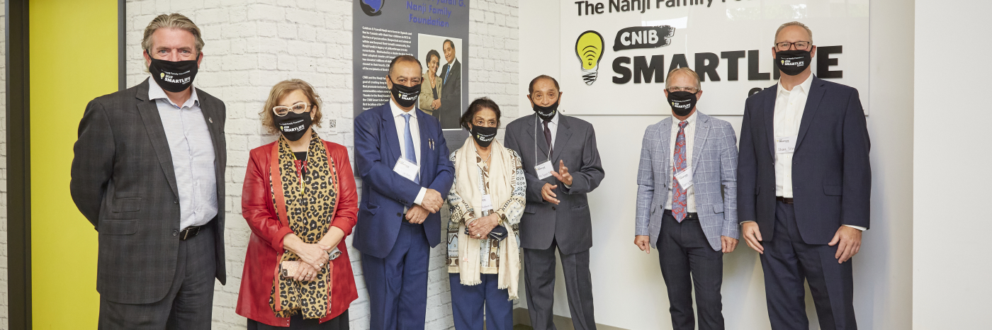 From left to right, John Rafferty, President and CEO of CNIB, Eyre Purkin Bien, Senior advisor, Philanthropy, three members of the Nanji Family, Garry Nenson Vice President of Philanthropy for CNIB, and Shane Silver, Vice President of Social Enterprises for CNIB. The group stands together in front of the new Nanji Family Foundation CNIB SmartLife Centre.