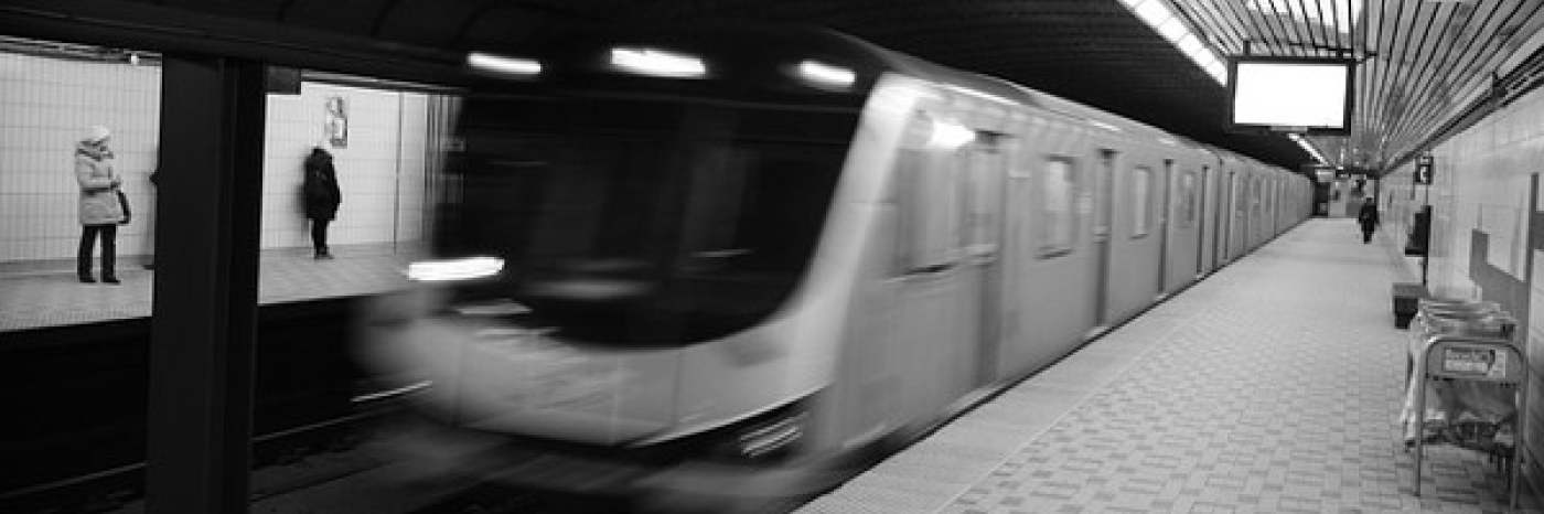 A blurry subway car breezes into a station.
