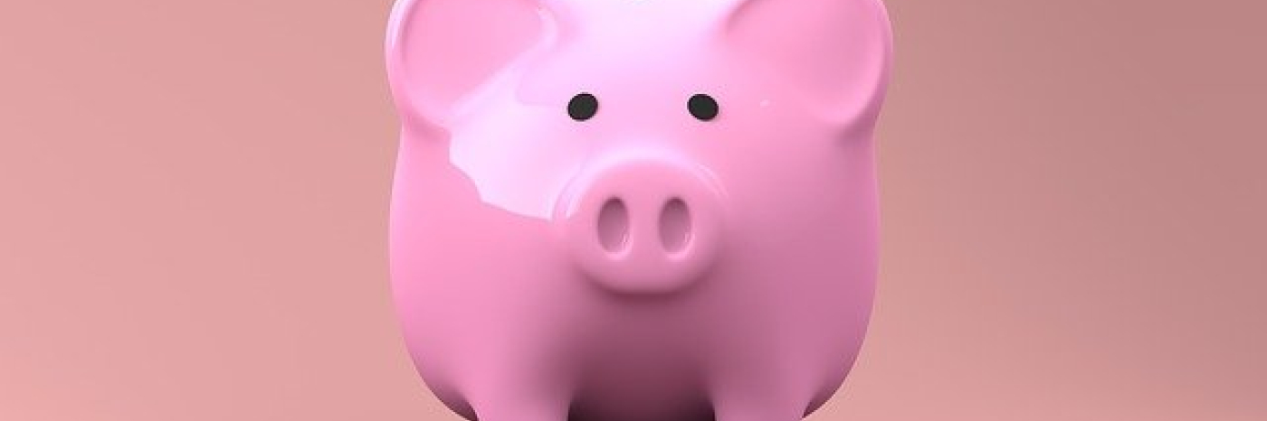 A pink piggy bank sits on a tabletop. 