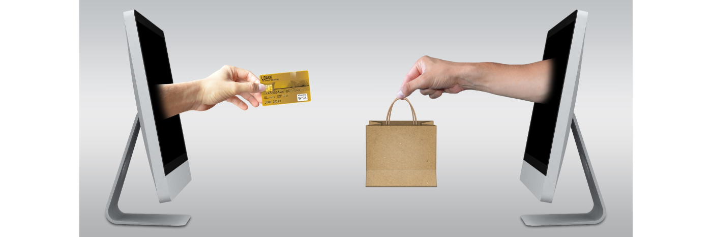 Two desktop computers with photoshopped pictures of hands coming out the monitors. On the left computer monitor, a hand is extended holding a credit card. On the right computer, a hand is extended holding a shopping bag.