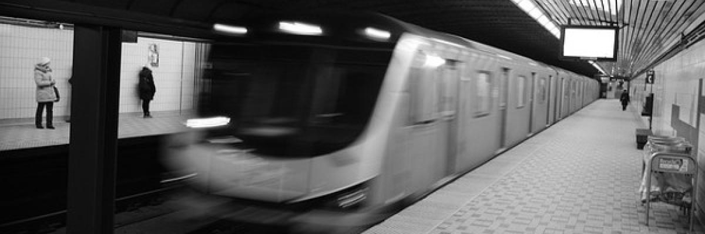A blurry subway car breezes into a station.