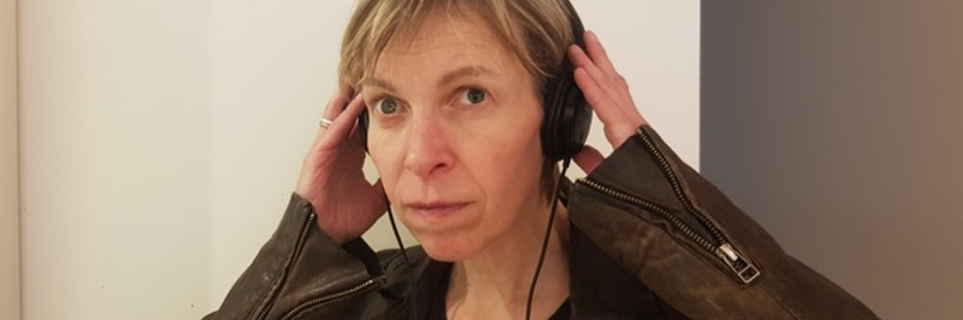 an image of Alex with earphones on smiling