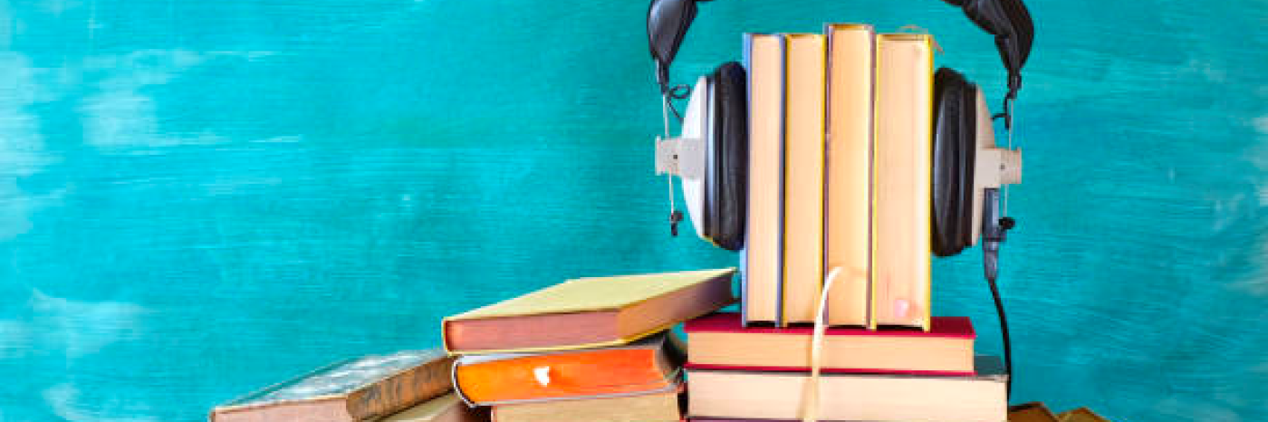 Stacks of books with headphones on top.