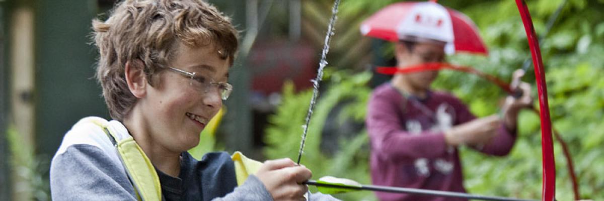 Boy with sight loss drawing a bow in archery