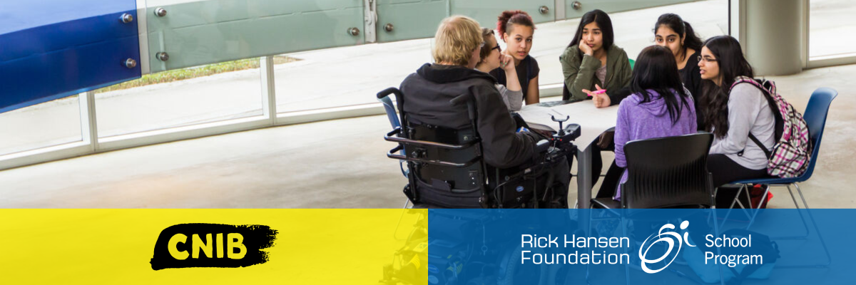 A group of seven young students sit together at a table in a classroom, participating in a shared learning activity. One of the students uses a wheelchair. At the bottom of the image is the CNIB logo on a yellow background and the Rick Hansen Foundation School Program logo on blue background.