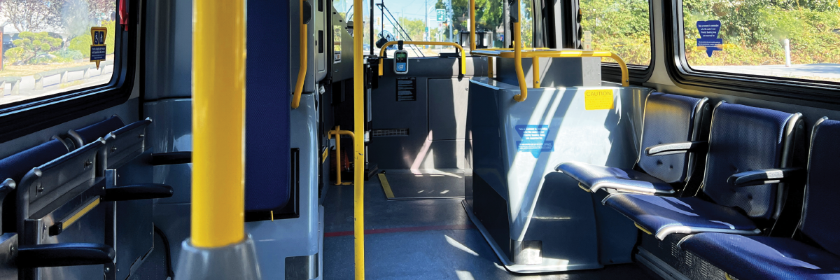The empty interior of a city bus. Rows and rows of empty seats.