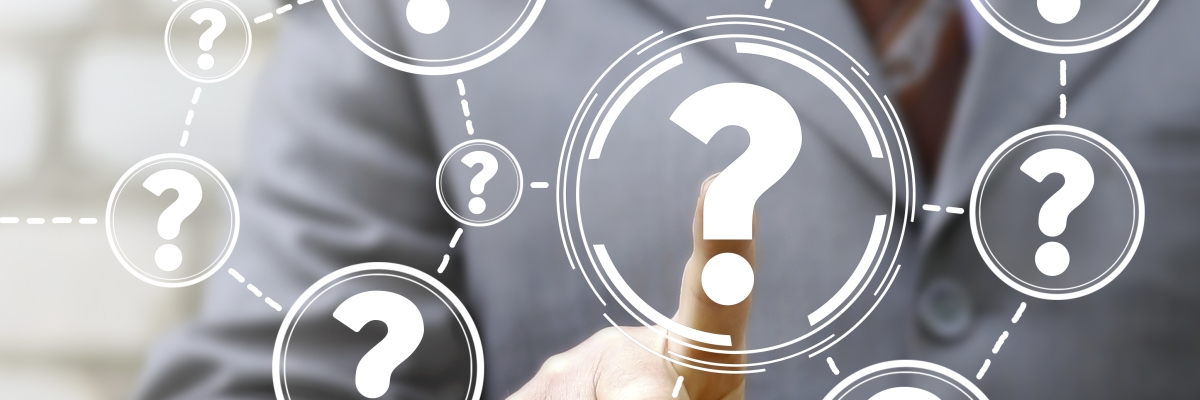 A finger points at a bunch of questions marks