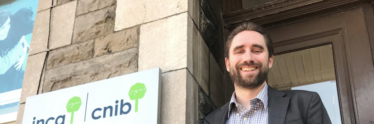 David Demers, cane in hand, stands proudly in front of the CNIB office.