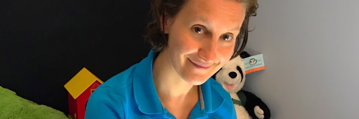 In this photo is Mindy Bodnarchuk, the child and Family Services Counsellor for Northern Saskatchewan. She is sitting on the floor of her office using her light box which she uses for assesments and training with her clients. Stuffed animals and toys are visible in the background.