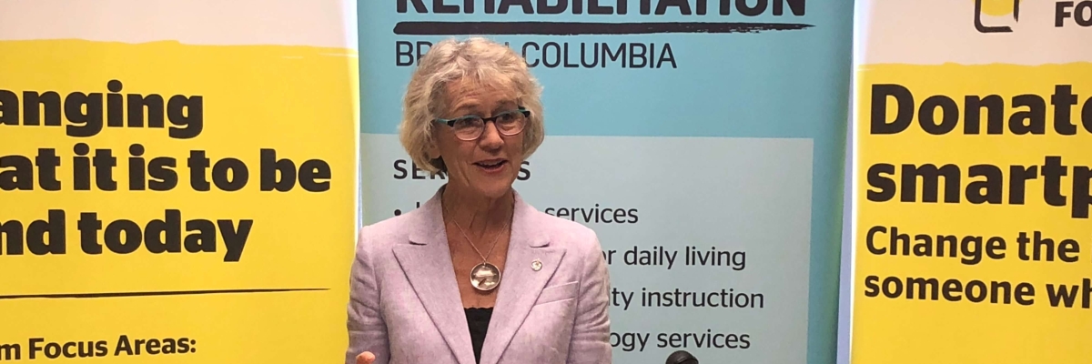 Minister Joyce Murray giving a speech in front of our CNIB and VLRC Banners