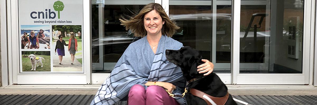 Shelley Adams and her guide dog Pogo, sitting on the steps of CNIB Halifax.