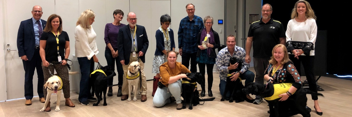 CNIB volunteer puppy raisers lined up with their guide dog puppies for a picture at CNIB Nova Scotia's Annual Community Meeting