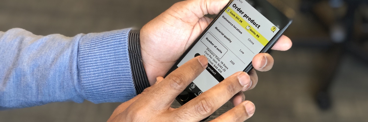 Image of a set of hands holding an iPhone with the Venture Zone Game app open on the screen, displaying the game’s “Add” menu, which lets players choose between various branding, marketing, production or funding options. 