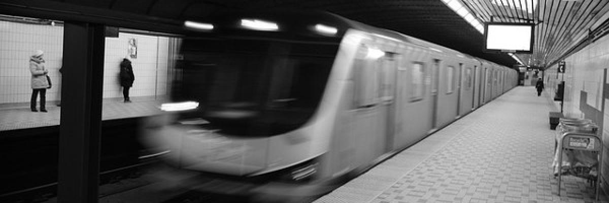A blurry subway car breezes into a station.